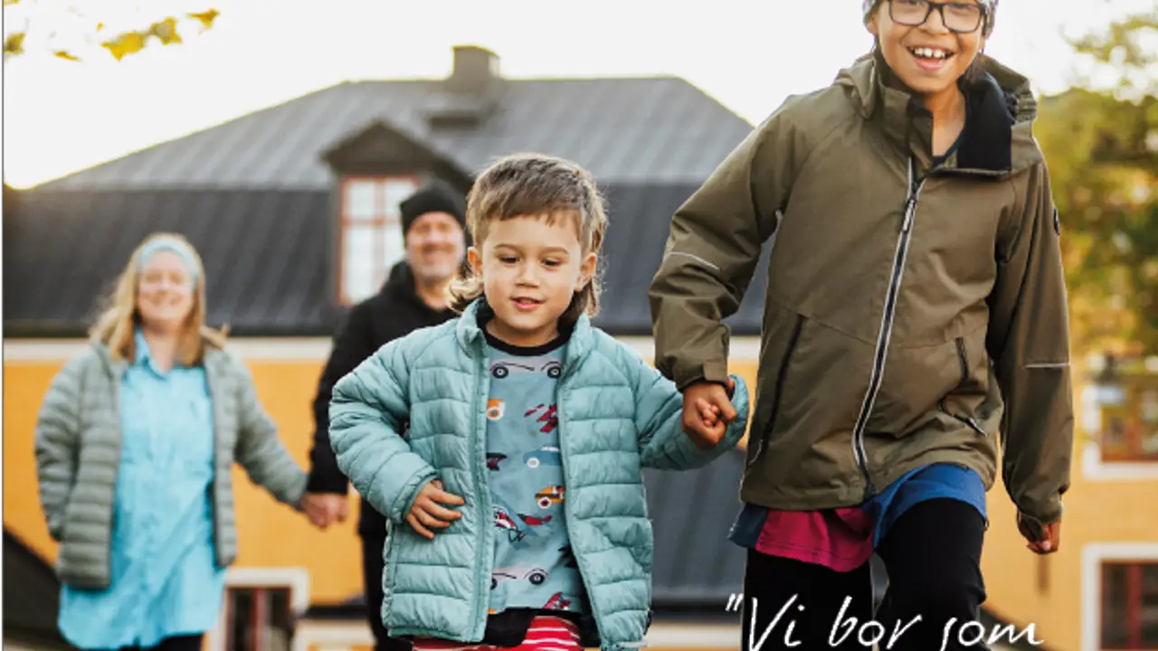 Barn och vuxna som går tillsammans utomhus i bostadsområde, omslagsbild till Karlskronahems kundtidning Grannar.